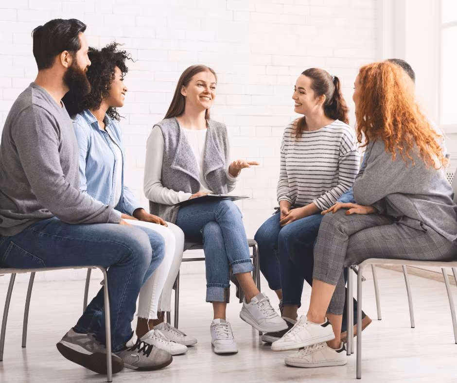 A group of people discussing addiction treatment options in a rehab center