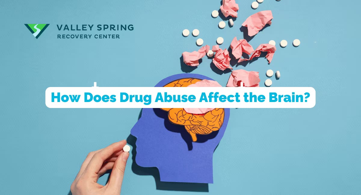 A paper cutout of a head with pills and crumpled paper scattering from it, illustrating how drug abuse affects the brain