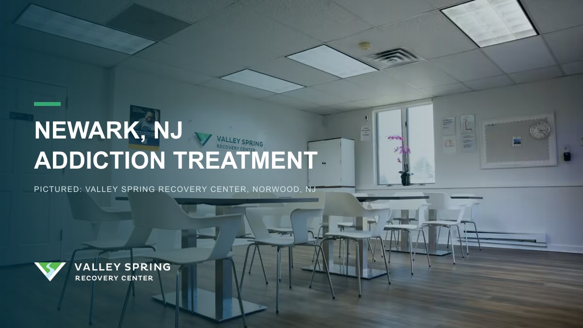 Dining area below the Valley Spring wall sign inside the treatment center in Norwood, New Jersey, branded for Newark substance use disorder treatment access