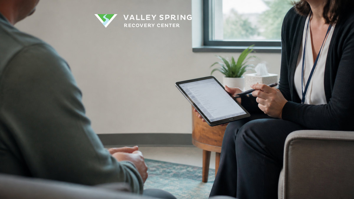 Clinician conducting a confidential substance-use screening with an adult before treatment placement