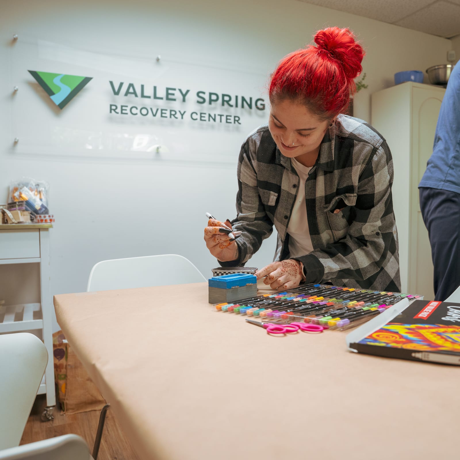 A client paints during an arts and crafts group beneath the Valley Spring Recovery Center sign in Norwood, NJ