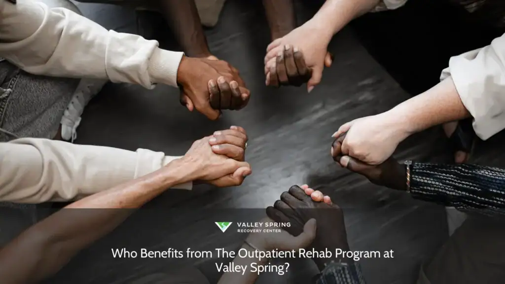 Hands of diverse individuals clasped together in unity, symbolizing support and community engagement at Valley Spring's outpatient rehab program.